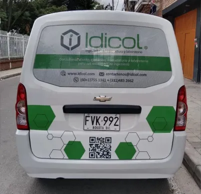 Parte trasera de la misma furgoneta rotulada, con el logotipo, el código QR y un patrón de hexágonos en vinilo de corte.