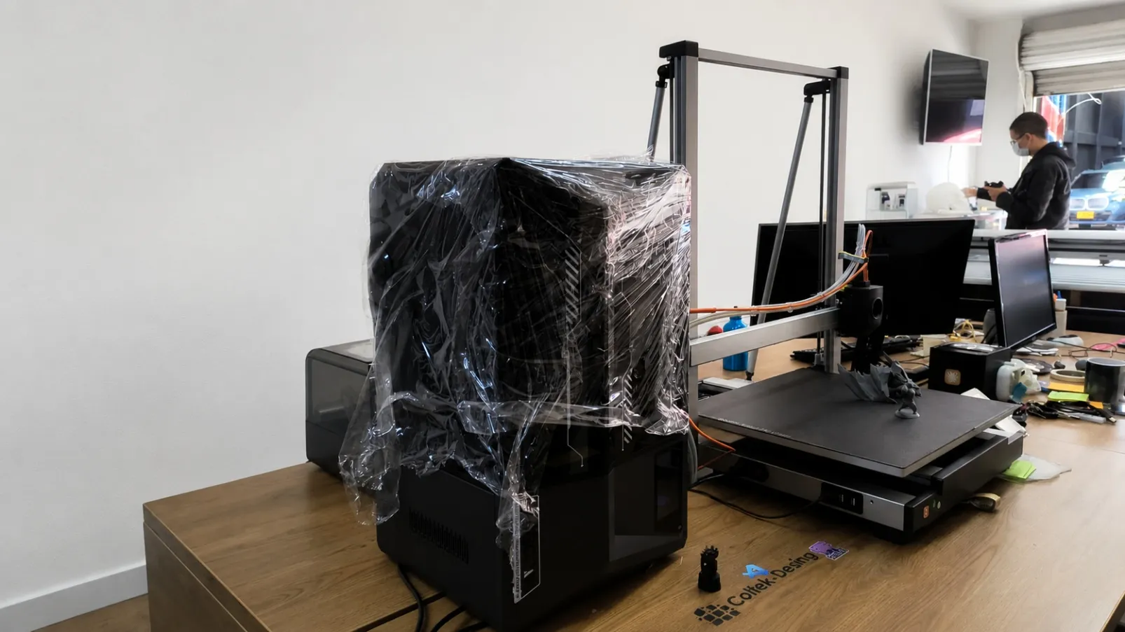 Zona de impresión 3D del taller: la impresora de resina recién llegada, todavía embalada, junto a la impresora de filamento en funcionamiento.
